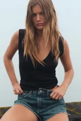 Camiseta negra de corte ajustado (slim fit) con escote pico pronunciado y manga sisa.