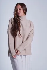 Sweater tejido de punto color beige, con cuello alto y trama lineal.