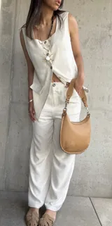 Conjunto color crudo compuesto por chaleco con botones y pantalón de lino.