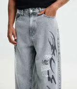 Pantalón masculino super baggy confeccionado en jeans sostenible con cintura con trabilla, cierre tradicional, bolsillos y estampa de grafiti.