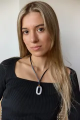 Collar con doble tira de tiento negro, una ajustada al cuello como choker y otra más larga con un dije ovalado de piedra natural blanca y un pequeño detalle dorado.