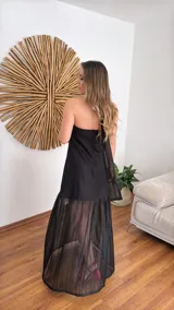 Vestido largo negro de tejido de punto con escote recto y breteles finos. La falda es de encaje transparente. Incluye una bufanda fina al tono.