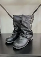 Botas de caña baja color negro con hebillas plateadas y efecto arrugado en el empeine.