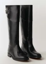 Bota alta de cuero negro, sin cierre y con punta redonda.