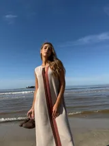 Vestido midi sin mangas color beige, con corte recto y detalle de franja vertical marrón en el centro.