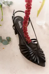 Sandalia negra de cuero con tiras finas entrecruzadas, punta fina, pulsera regulable en el tobillo y taco bloque.