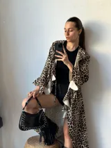 Maxi camisa con estampado animal print de leopardo, con cuello camisero, mangas largas con puños abotonados y volados en el frente.