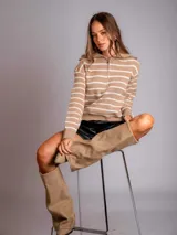 Sweater color beige a rayas horizontales blancas, con cuello polo y cierre metálico.