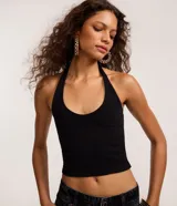 Blusa blanca de punto roma, con diseño de cuello halter que deja la espalda descubierta.