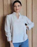Blusa celeste con cuello mao y mangas abullonadas.