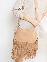 Bandolera de gamuza color beige con flecos largos en la parte inferior. Tiene correa larga regulable del mismo material.