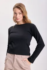 Remera negra de tejido rib con mangas largas y cuello redondo.