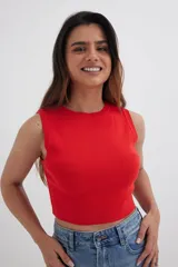 Top tejido fucsia con cuello redondo y sisas amplias.