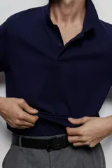 Remera polo azul marino de piqué de algodón, corte regular, manga corta, cuello clásico y tapeta de botones.