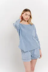 Remera celeste de manga larga con cuello redondo y bolsillo en el pecho.