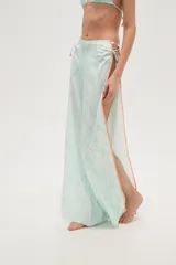 Pantalón largo de tela estampada en tonos celeste y blanco, con aberturas laterales que se sujetan con tiras entrecruzadas.