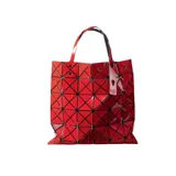 Bolso tote rojo con diseño geométrico facetado, doble asa superior y etiqueta colgante.