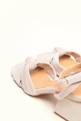 Sandalia de terciopelo verde con taco cuadrado de 7 cm, punta cuadrada y tiras anchas anudadas en el empeine. Cuenta con una tira fina ajustable al tobillo con hebilla dorada.