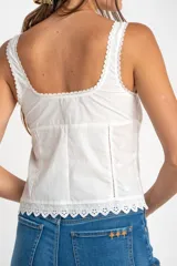 Musculosa blanca de algodón con bordado calado, alforzas y terminaciones de puntilla.