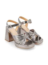 Sandalias plateadas con plataforma y tacón cuadrado, tiras cruzadas en el empeine y pulsera con hebilla al tobillo.
