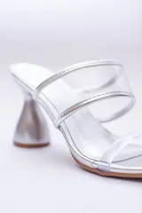 Sandalias plateadas con taco de forma geométrica y tiras transparentes.