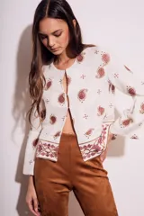 Blusa blanca con estampado de cachemir en color marrón y bordado floral en el ruedo y mangas acampanadas.