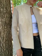 Campera color beige con mangas largas de tejido de punto y cuerpo de cuero sintético. Interior con estampado animal print.