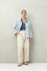 Pantalón color crema de corte ancho, con cintura alta y pinzas delanteras.