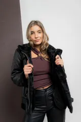Gamulan negro de ecocuero con interior de símil piel, cuello solapa y cierre lateral con cremallera.