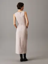 Vestido largo de punto milano color beige, sin mangas, con cuello barco, corte slim y panel trasero recortado.