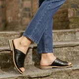 Sandalias bajas de cuero vacuno color negro, con suela de goma y horma de punta redonda. Producto de horma chica, se recomienda pedir un talle más.