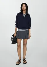 Sweater beige de cuello alto con cierre de cremallera, diseño oversize y mangas largas.