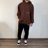 Canguro marrón con capucha, corte oversize, bolsillo tipo canguro y puños ajustados.
