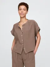 Camisa de muselina color blanco, con cuello mao y mangas cortas.