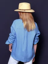 Camisa de lino color lila, de corte clásico, con cuello camisero y mangas largas con puños abotonados.
