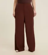 Pantalón de vestir marrón de corte wide leg, confeccionado en viscosa y poliéster. Presenta cintura con elástico en la espalda y cierre delantero con ganchillo, botón y cremallera.
