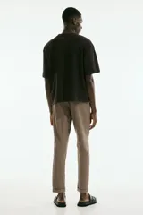 Pantalón de vestir color beige, de corte slim fit, con cintura elástica y cordón ajustable.