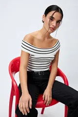 Pantalón de jean azul oscuro, de corte flare con cinturón incorporado en la misma tela y silueta ajustada en cadera que se ensancha hacia el ruedo.