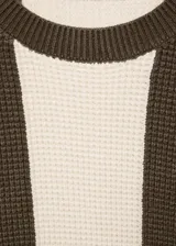 Sweater de punto con rayas horizontales anchas en color marrón y blanco. Tiene cuello redondo y mangas largas.