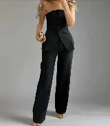 Conjunto sastrero negro de dos piezas, compuesto por un top strapless con botones y un pantalón de vestir de corte recto.
