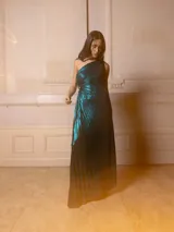 Vestido largo de fiesta color violeta metalizado, con textura plisada y diseño de un solo hombro.