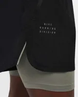 Short de running Nike Running Division, color negro, con short interior gris. Cuenta con tecnología Dri-FIT, tejido Ripstop repelente al agua, bolsillos laterales y trasero con cremallera, y bolsillo interior.