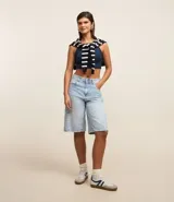 Blusa sin mangas color marrón, confeccionada en tejido rib con textura. Presenta cuello halter que resalta los hombros.