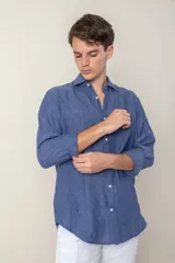 Camisa celeste de lino con cuello clásico y manga larga. Presenta un pequeño logo bordado en el pecho.