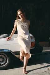 Vestido midi color beige, de viscosa, con escote asimétrico y detalle de crochet en el hombro.