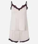 Conjunto de pijama compuesto por un top de breteles finos y un short, ambos en color crema con detalles de encaje color borgoña en los bordes.