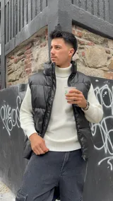 Sweater blanco de punto con cuello alto y mangas largas.