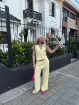 Conjunto de dos piezas color azul eléctrico, compuesto por un chaleco de manga corta con escote en V y botones frontales, y un pantalón de tiro alto con pierna ancha y pliegues.