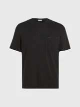 Remera negra de corte regular, cuello redondo y manga corta. Cuenta con un bolsillo de parche en el pecho y etiqueta tonal del logo de Calvin Klein.