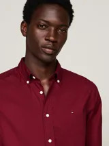 Camisa de manga larga color rojo con cuello abotonado y logo de Tommy Hilfiger bordado en el pecho.